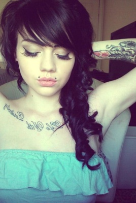  Piercing angel-bites sur femme avec un tatouage au bras et sous le cou 