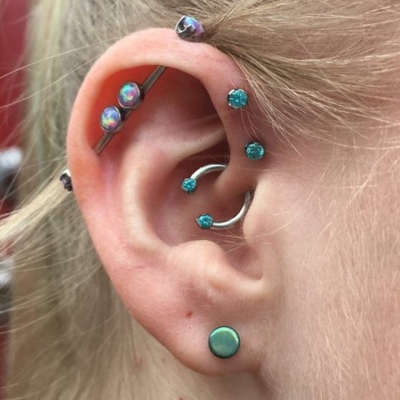  Deux piercings anti-hélix, un industriel et un daith avec un circulaire 
