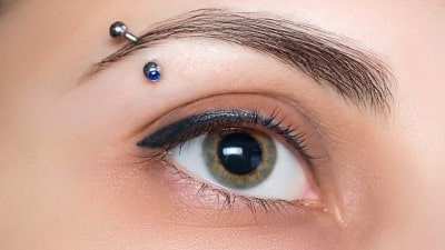  Piercing arcade avec une banane ornée de deux strass bleus
