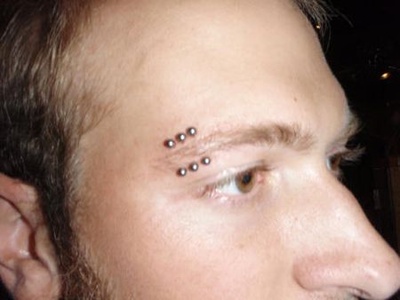  Triple piercing de l’arcade sourcilière avec des bananes boules en acier 