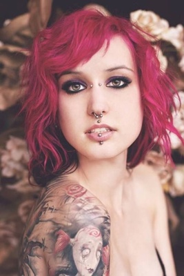  Piercing bridge, septum, médusa et labret vertical sur femme tatouée aux cheveux rouges 