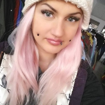  Piercing cheek, joue, fossette plaqué titane noir sur femme aux cheveux roses 