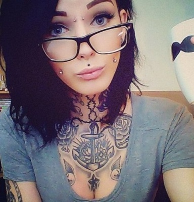  Piercing cheek, joue, fossette sur femme avec des tatouages au coup et au dessus de la poitrine: 