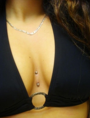  Piercing cleavage / sternum avec un haut de maillot de bain noir 