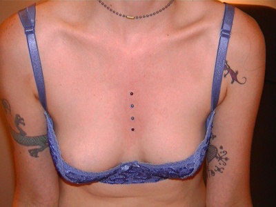 Piercing cleavage / sternum sur fille avec tatouage 