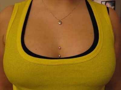 Piercing cleavage / sternum sur une femme avec un tee-shirt jaune 