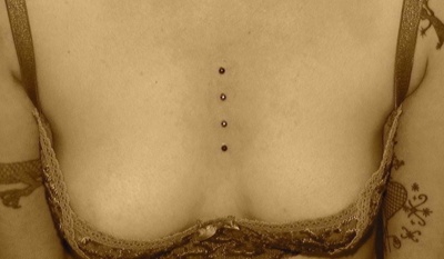 Quadruple Piercing cleavage / sternum avec une photo style vieillie 