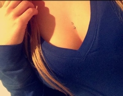  Piercing cleavage / sternum sur femme avec un haut bleu 