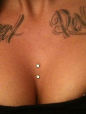  Piercing cleavage / sternum deux strass sur femme tatouée 