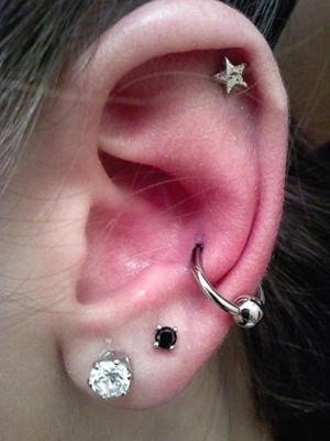  Piercing conch / conque avec un anneau classique argenté et un piercing hélix en forme d’étoile 