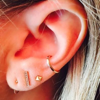  conch / conque avec un anneau jaune et divers piercings du lobe 