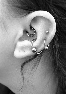  Piercing conch / conque avec un anneau simple, des piercings hélix et un daith