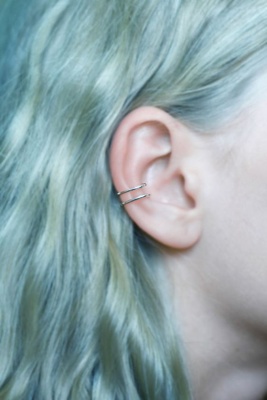  Double piercing conch / conque sur une femme aux cheveux turquoise