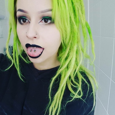  Piercing langue venom sur femme avec des cheveux verts 