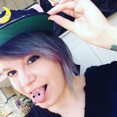  Piercing langue venom sur femme aux cheveux violets 