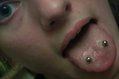 Piercing langue venom ou double piercing langue en gros plan avec deux bijoux argentés 