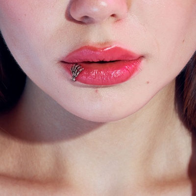  Piercing labret décalé avec un piercing qui représente un squelette de main 