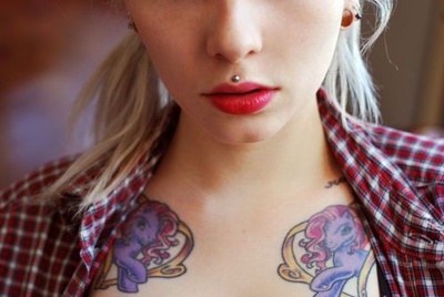  Double piercing medusa boule sur femme avec deux tatouages au dessus de la poitrine 