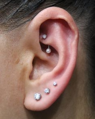 Piercing rook avec une banane perle et trois boucles au lobe de l'oreille 
