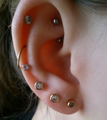  Piercing rook avec une banane grise et de multiples piercings sur les bords de l’oreille 