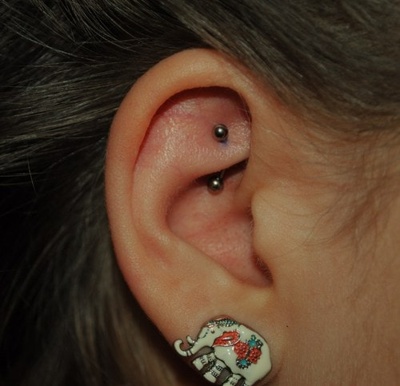  Piercing rook avec une banane grise et une boucle d’oreille éléphant sur le lobe 