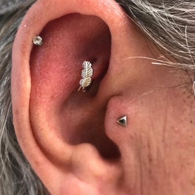  Piercing rook avec une jolie plume, piercing hélix et un piercing triangulaire au tragus 