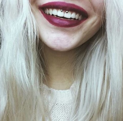 Piercing smiley / frein labial avec un fer à cheval sur femmes aux cheveux blonds clairs 