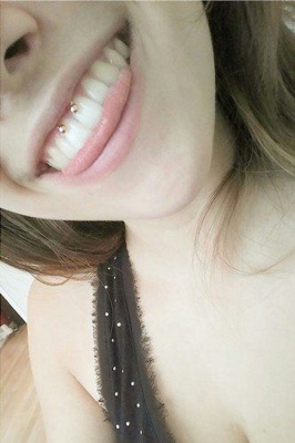  Piercing smiley / frein labial sur femme qui tire la langue