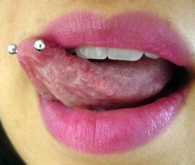  Piercing langue snake-eyes sur une langue pliée vers le haut.