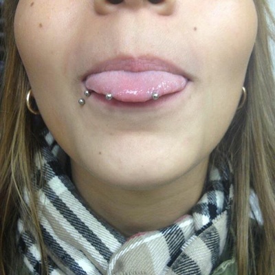  Piercing langue snake-eyes et labret décalé.