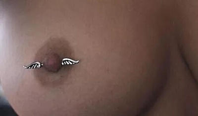  Piercing téton barbell avec des ailes d’ange sur femme 