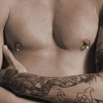  Deux anneaux de téton sur homme tatoué 