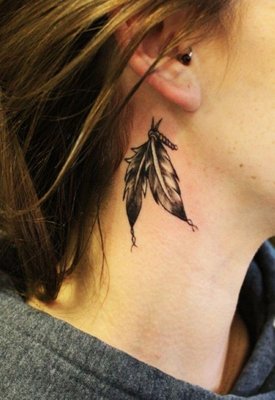  Tatouage de deux plumes sous l’oreille 