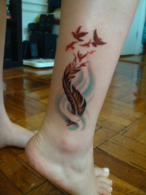  Tatouage plume colorée au dessus de la cheville 